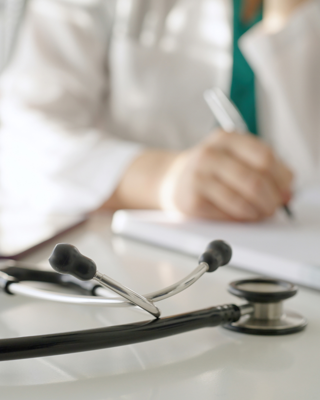 Doctor tomando notas en consulta